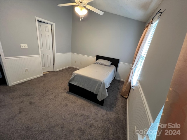 bedroom featuring dark colored carpet, a textured ceiling, vaulted ceiling, and ceiling fan