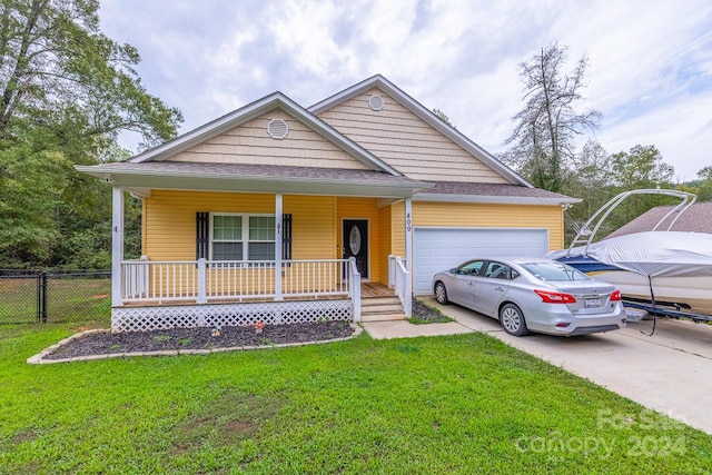 view of front of house featuring a front yard, a garage, and covered porch