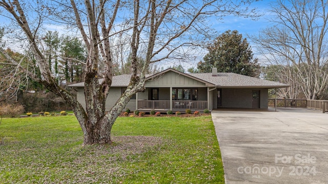 view of front of property with a front lawn, covered porch, and a carport