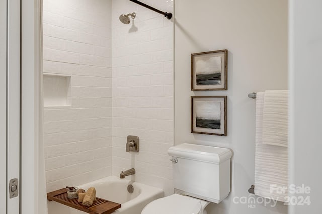 bathroom featuring toilet and tiled shower / bath