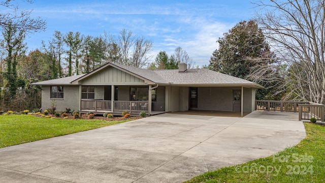 ranch-style house featuring a front yard, a porch, and a carport