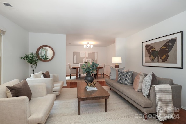 living room with light hardwood / wood-style floors and a notable chandelier