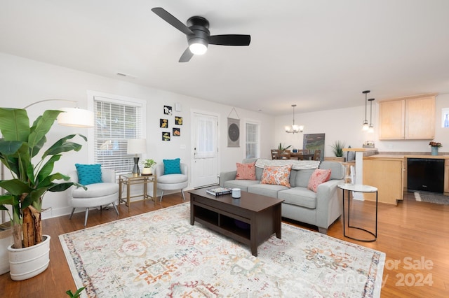 living room with wood-type flooring and ceiling fan with notable chandelier