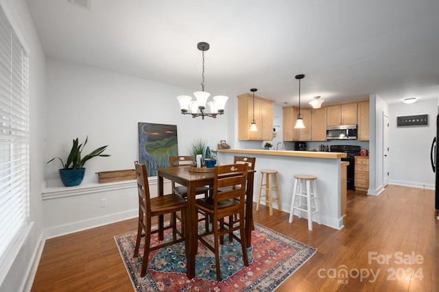 dining space featuring a notable chandelier and hardwood / wood-style flooring