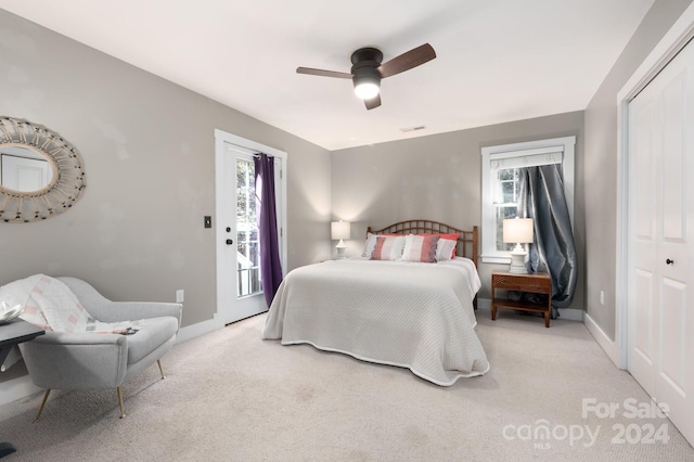 bedroom with access to outside, a closet, light colored carpet, and ceiling fan