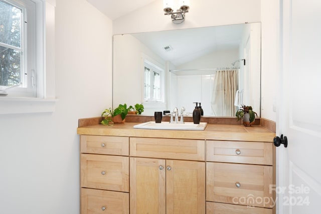 bathroom with vanity, lofted ceiling, and a shower with curtain