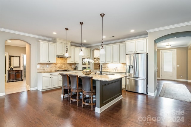 kitchen featuring stainless steel appliances, dark hardwood / wood-style flooring, sink, an island with sink, and light stone countertops