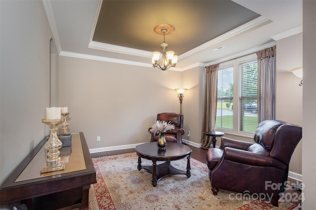 living area featuring a chandelier, a tray ceiling, wood-type flooring, and ornamental molding