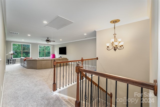 hall with a notable chandelier, carpet floors, and crown molding