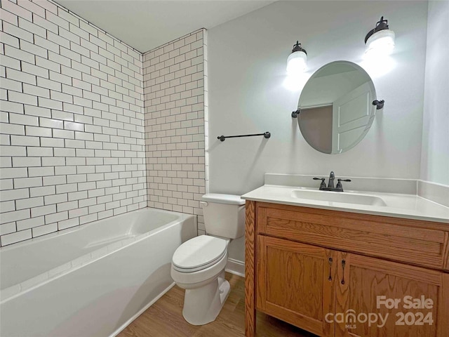 full bathroom featuring toilet, tiled shower / bath combo, hardwood / wood-style flooring, and vanity