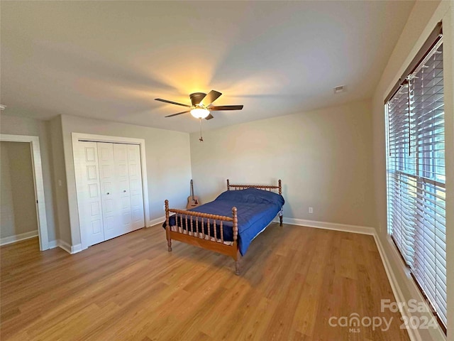 bedroom with a closet, ceiling fan, and light wood-type flooring