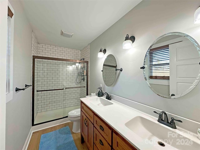 bathroom featuring toilet, an enclosed shower, vanity, and wood-type flooring