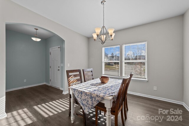 dining room featuring an inviting chandelier and dark wood-type flooring