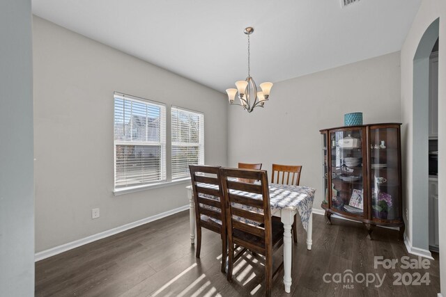 dining area with a notable chandelier and dark hardwood / wood-style floors