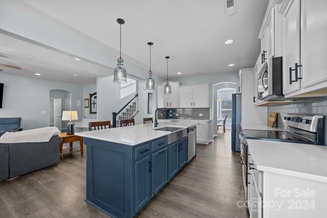 kitchen with white cabinetry, blue cabinetry, sink, decorative light fixtures, and stainless steel appliances