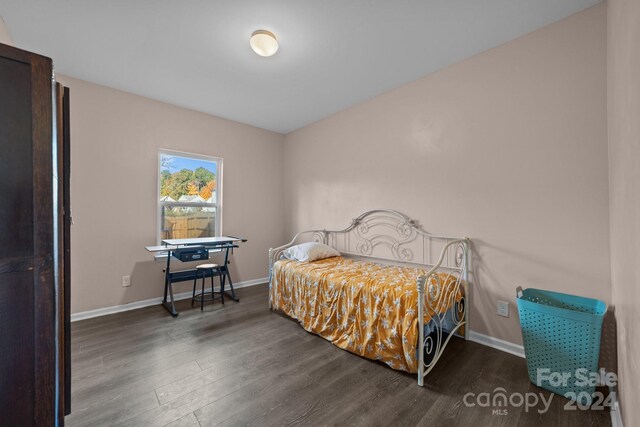 bedroom with dark wood-type flooring