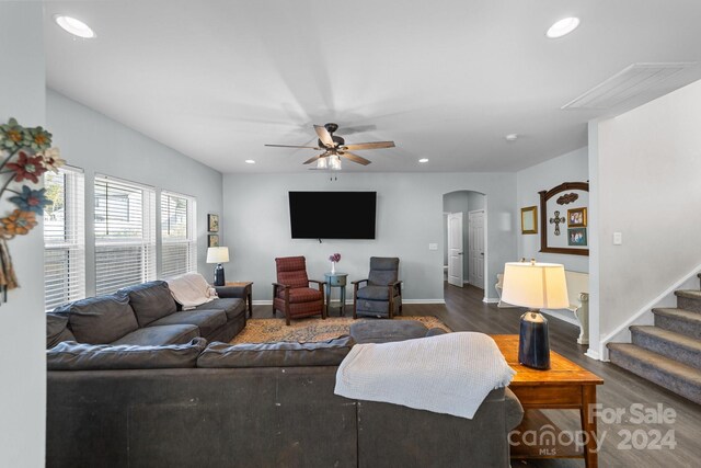 living room with dark wood-type flooring and ceiling fan