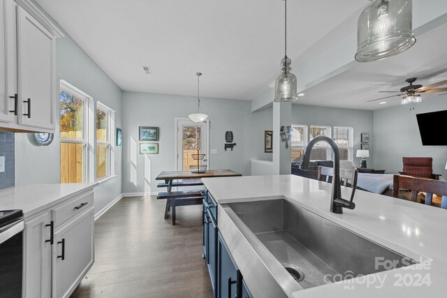 kitchen featuring sink, white cabinetry, ceiling fan, pendant lighting, and dark hardwood / wood-style floors