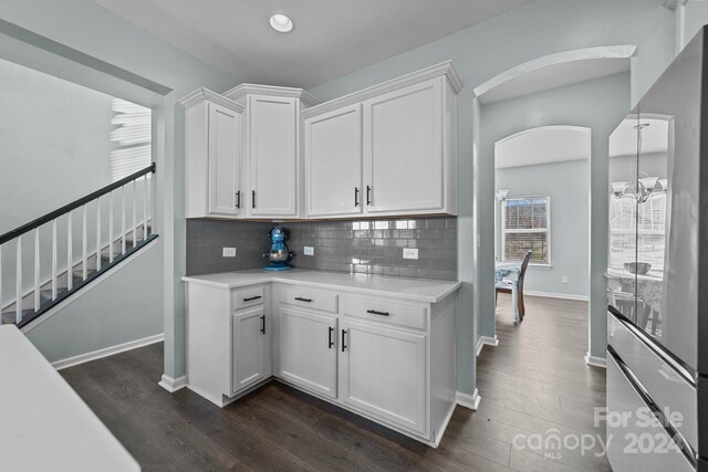 kitchen featuring a notable chandelier, white cabinetry, dark wood-type flooring, and backsplash