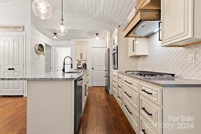 kitchen featuring cream cabinetry, an island with sink, sink, pendant lighting, and appliances with stainless steel finishes