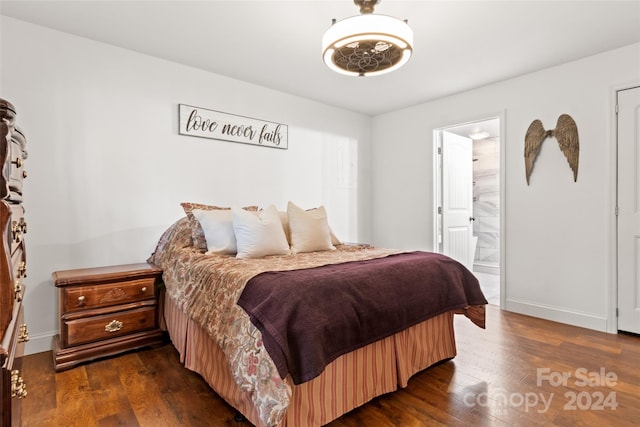 bedroom with dark hardwood / wood-style floors and ensuite bath