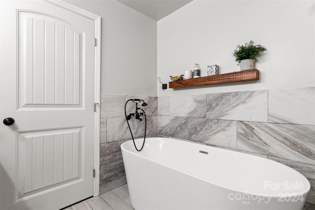 bathroom with tile walls and a washtub