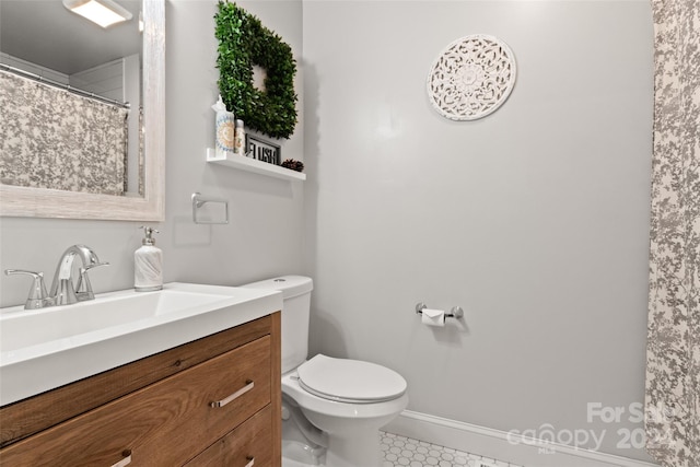 bathroom featuring toilet, vanity, and tile patterned flooring