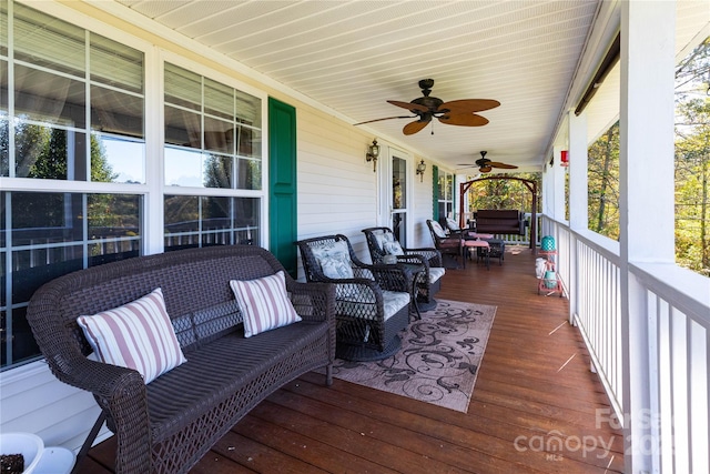 wooden deck with covered porch, ceiling fan, and outdoor lounge area