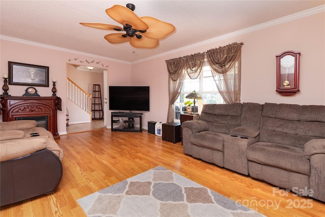 living room with ceiling fan, crown molding, and hardwood / wood-style flooring