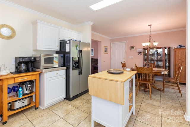 kitchen featuring stainless steel appliances, white cabinets, a notable chandelier, pendant lighting, and crown molding