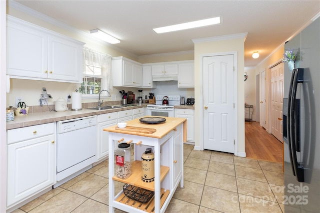 kitchen with white appliances, light tile patterned floors, a kitchen island, white cabinetry, and sink