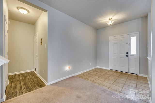 carpeted foyer featuring a textured ceiling