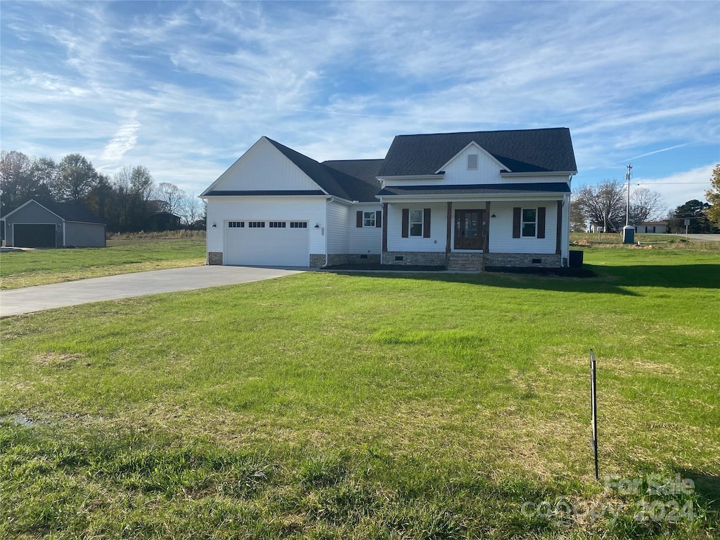 view of front of house featuring a front yard, a porch, and a garage