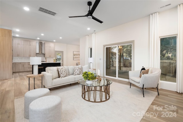 living room featuring light wood-type flooring, ceiling fan, and sink