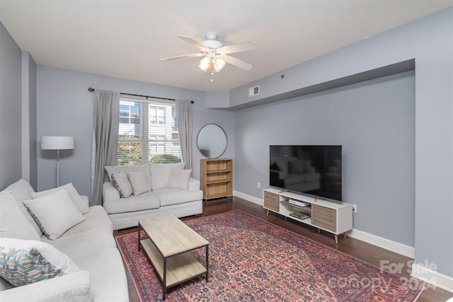 living room featuring ceiling fan and dark hardwood / wood-style flooring