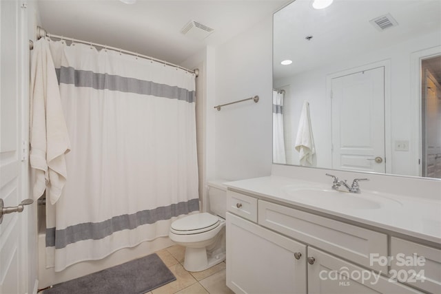 bathroom with vanity, a shower with curtain, toilet, and tile patterned flooring