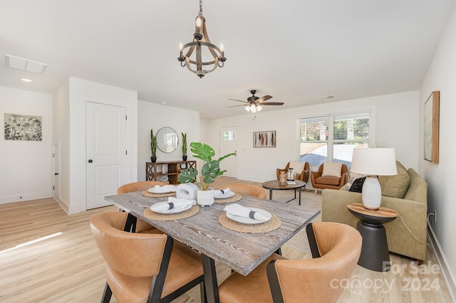 dining space featuring ceiling fan with notable chandelier and light hardwood / wood-style floors