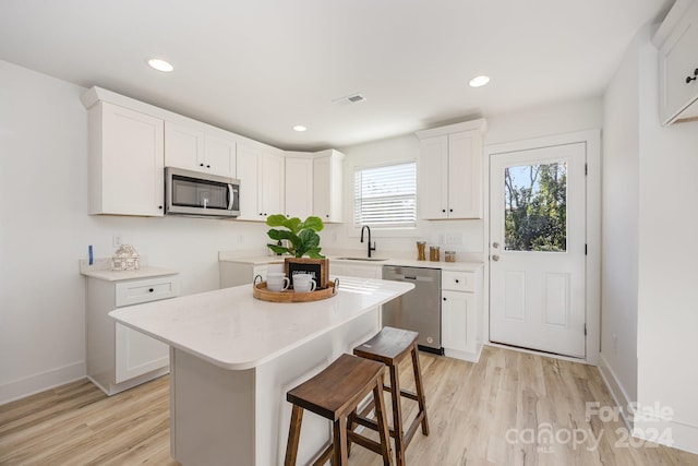 kitchen featuring white cabinets, plenty of natural light, appliances with stainless steel finishes, and a center island