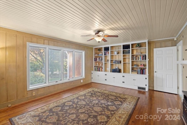 sitting room featuring wood walls, wood ceiling, wood-type flooring, built in shelves, and ceiling fan