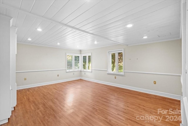 unfurnished room with crown molding, light wood-type flooring, and wooden ceiling