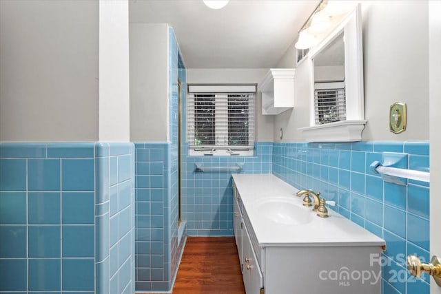 bathroom with vanity, hardwood / wood-style flooring, and tile walls