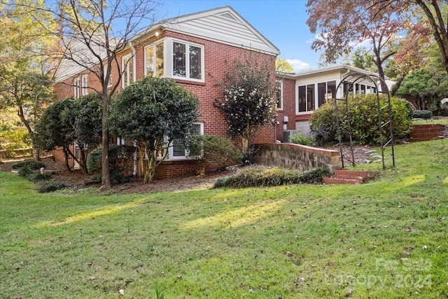 view of side of home with a lawn