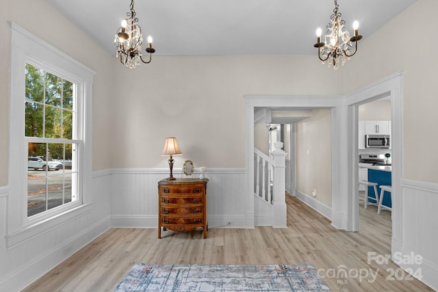 interior space with light hardwood / wood-style floors and an inviting chandelier