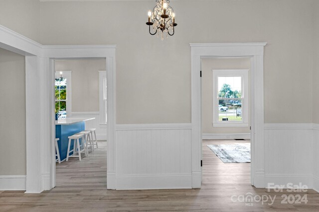 hallway featuring light hardwood / wood-style flooring and a notable chandelier