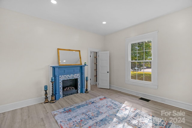 interior space with a tiled fireplace and light wood-type flooring