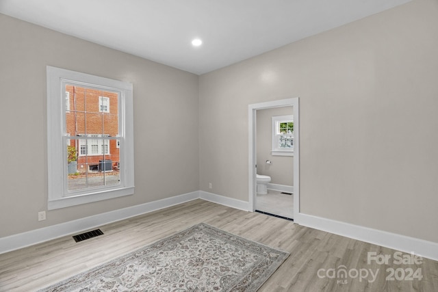 empty room featuring light wood-type flooring and a healthy amount of sunlight