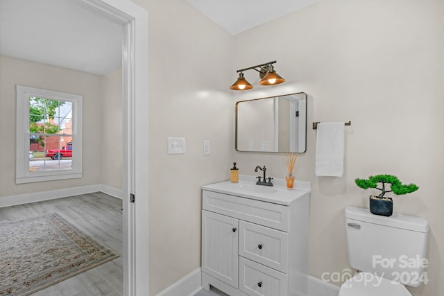 bathroom featuring vanity, hardwood / wood-style floors, and toilet