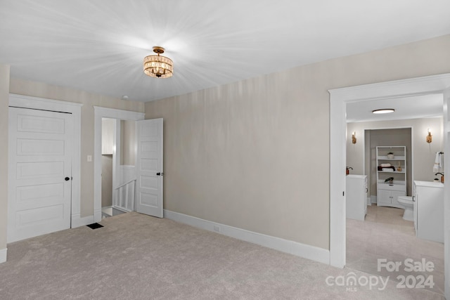 unfurnished bedroom with a closet and light colored carpet