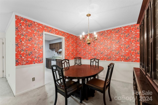 carpeted dining area with ornamental molding, a textured ceiling, and a chandelier