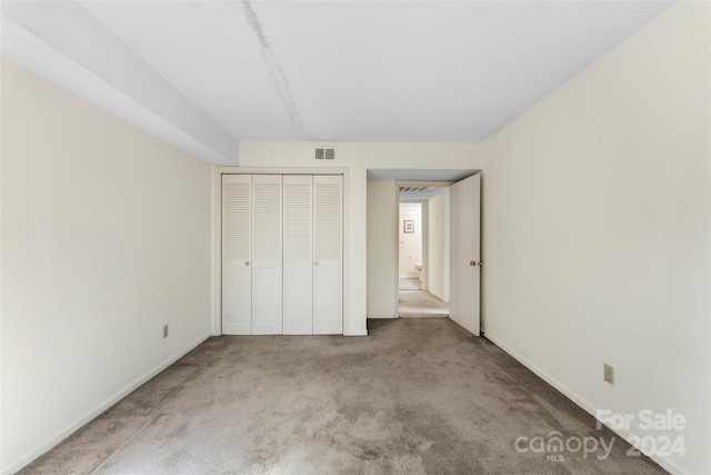 unfurnished bedroom with a closet and carpet floors